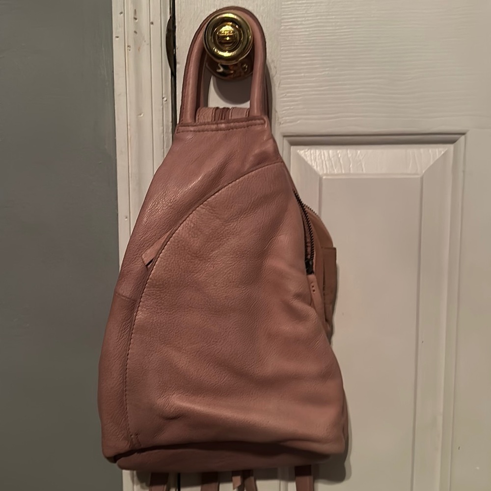 Sling purse that changes to a backpack with a zipper strap